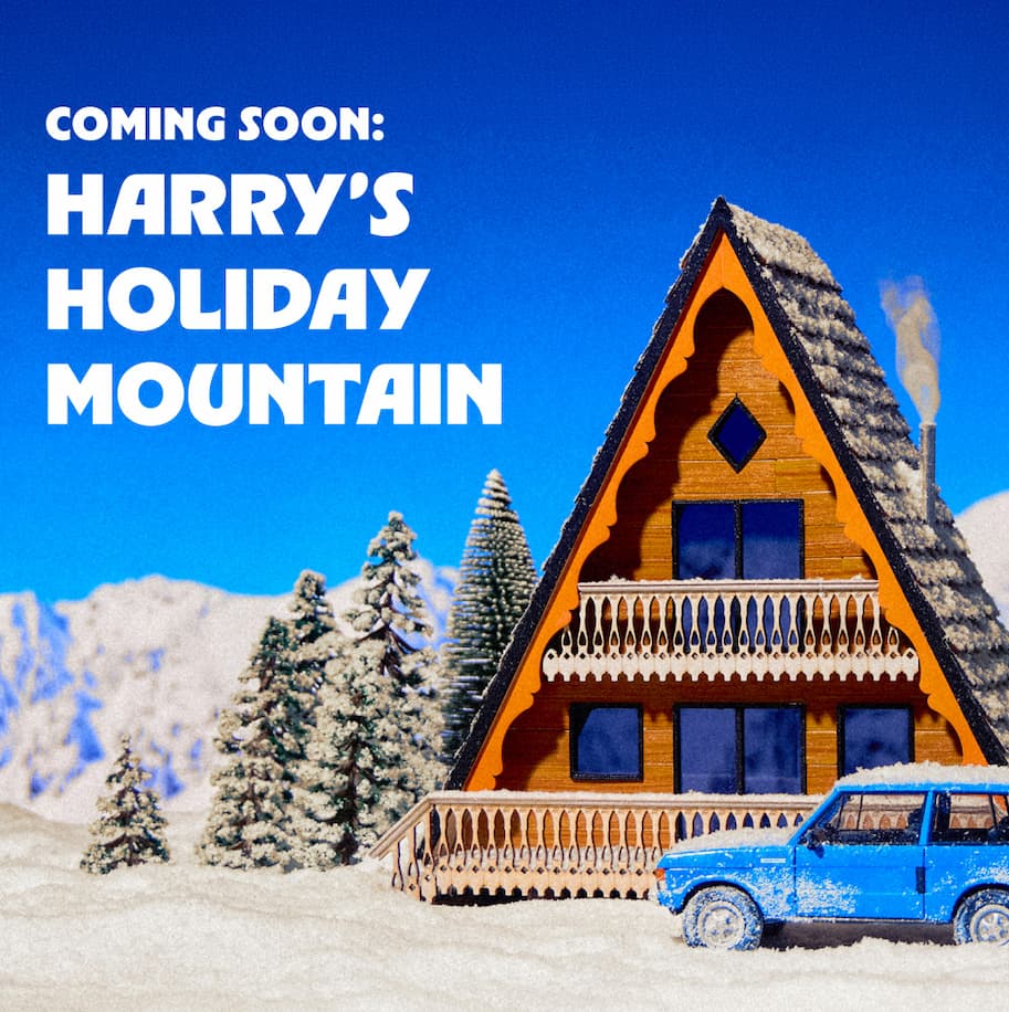 Miniature snowy cabin scene with a blue vintage SUV