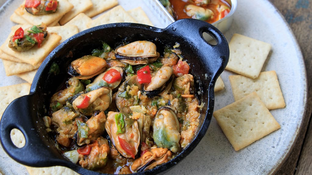 A small cast-iron skillet filled with mussels.