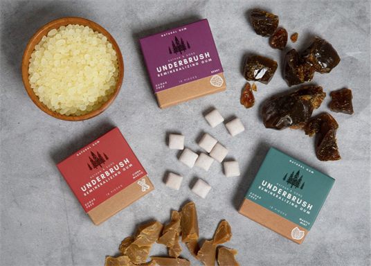 Underbrush gum boxes surrounded by natural ingredients