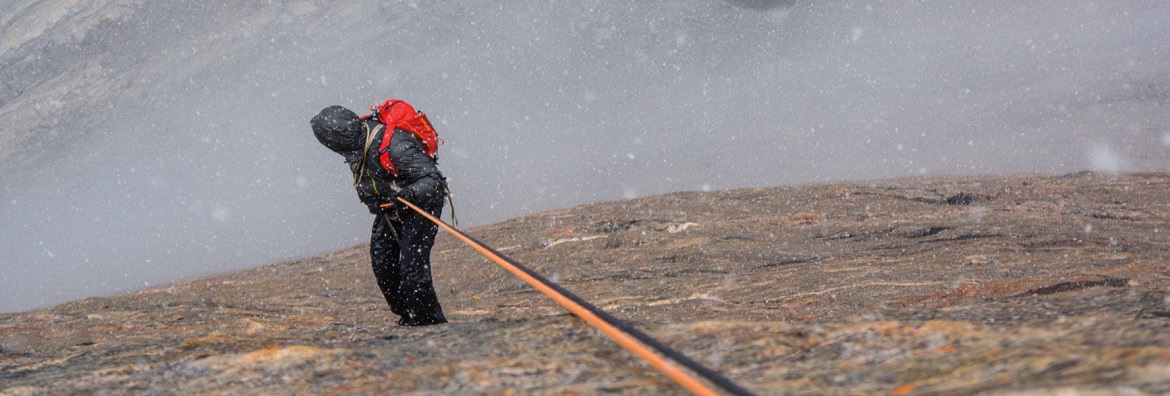 Down To Rally. A person rappels in cold, snowy conditions.