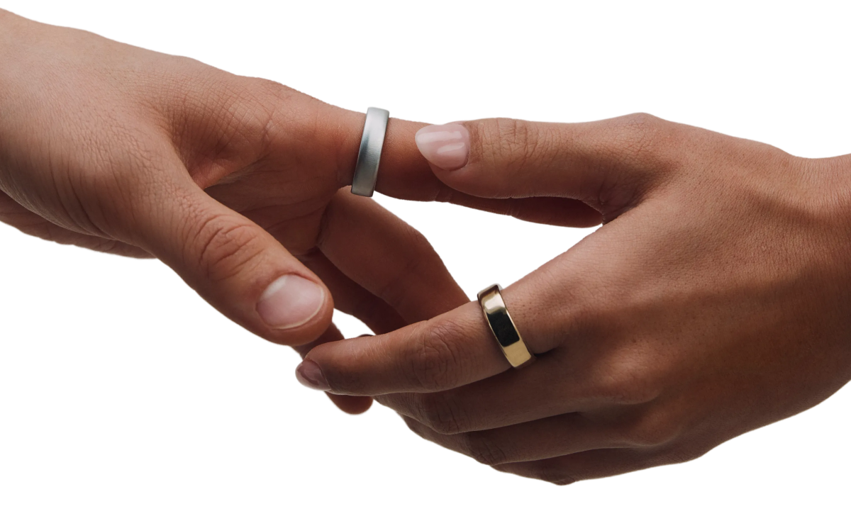 two hands touching with Oura Ring 5 on in brushed titanium and silver