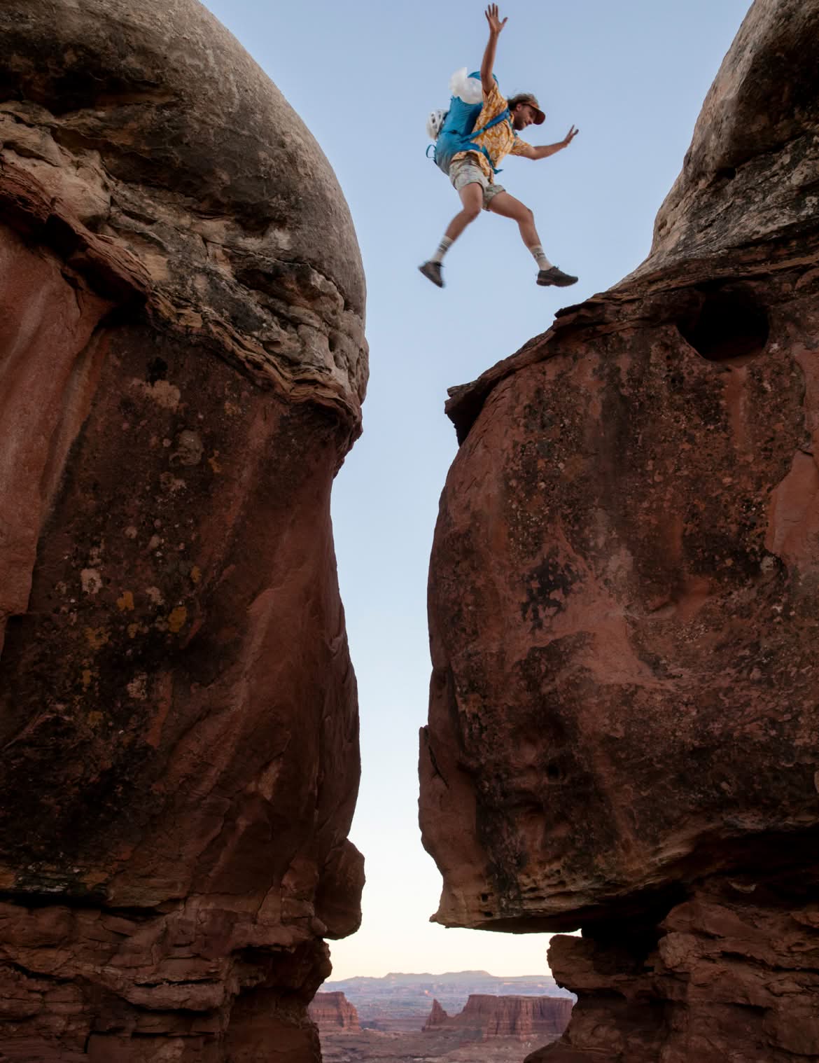 A person jumping between two boulders.