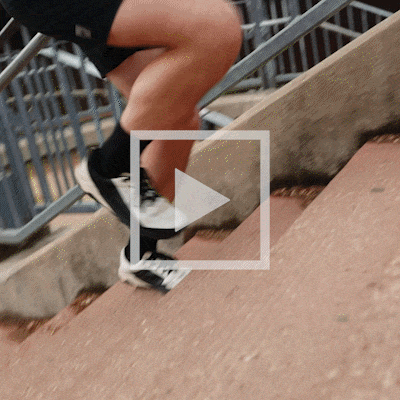 Zach Bitter running up a set of stairs and cooling off by pouring water from his bottle over himself.