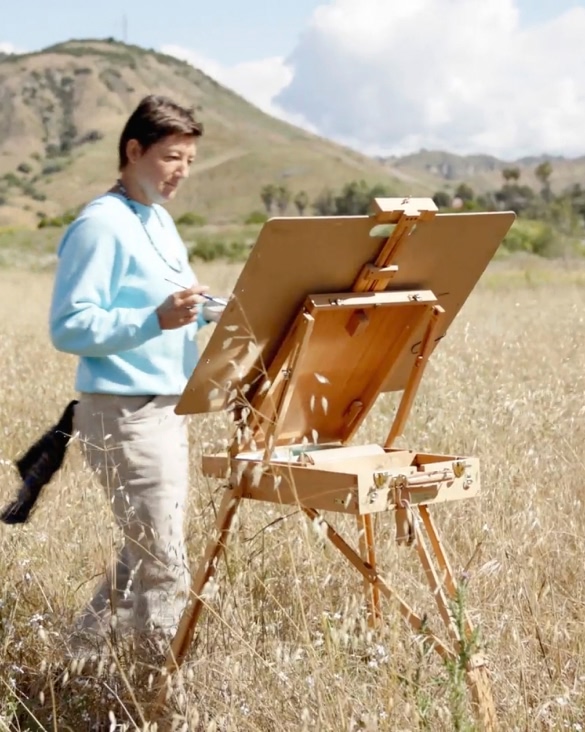 A plein air painter working at an easel. 