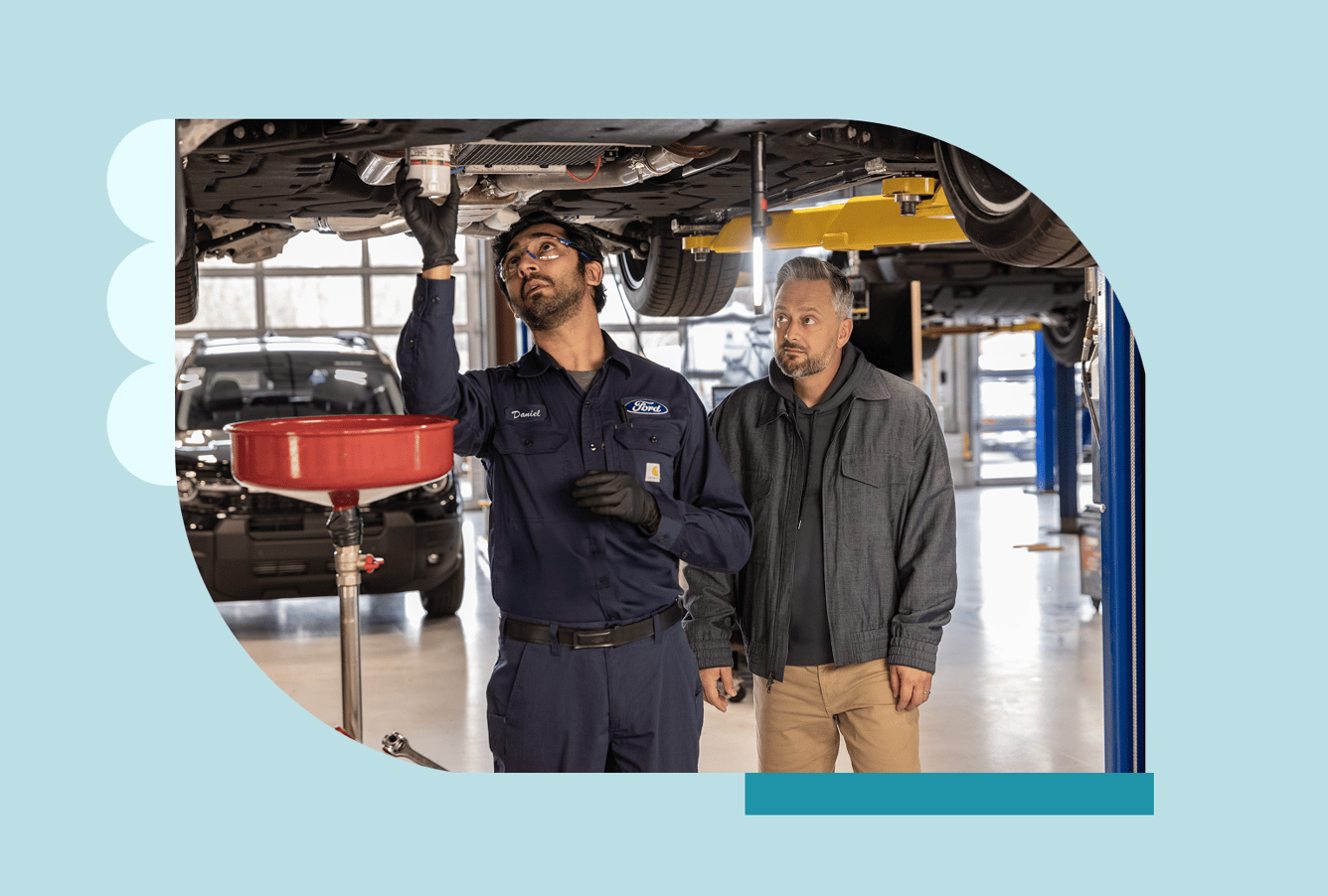 A Ford service technician stands next to comedian Nate Bargatze