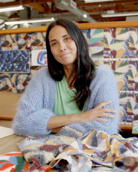 A designer surrounded by textile patterns.