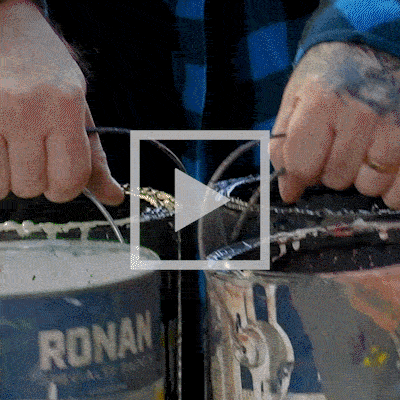 Justin Odaffer speaks on camera, followed by scenes of him painting a mural on a building and carrying buckets of paint.