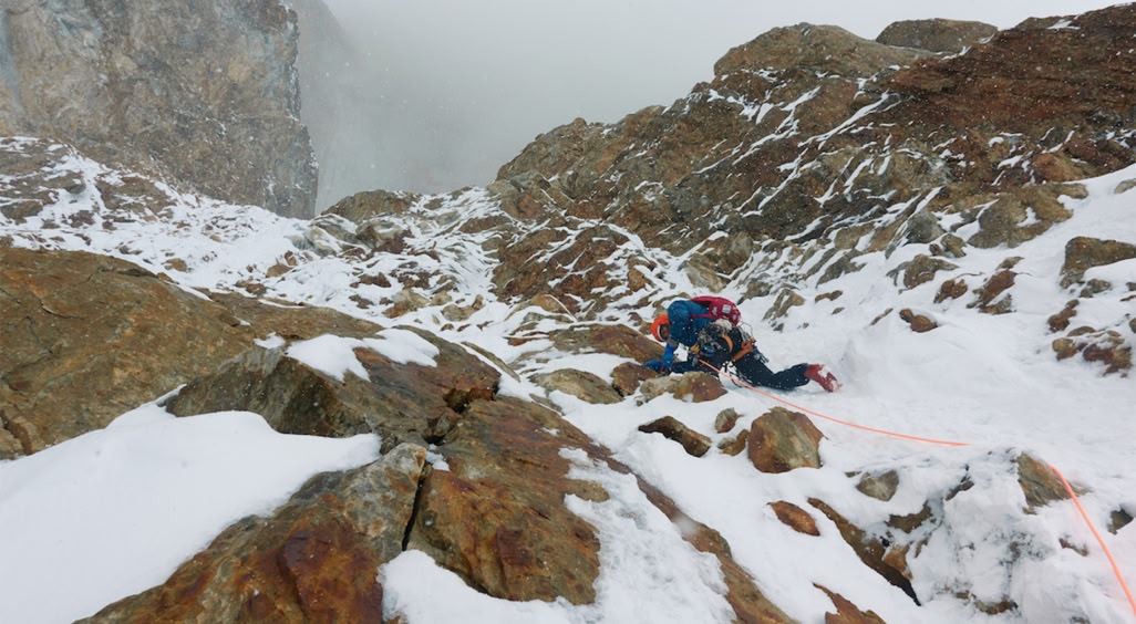 Climber dealing with rock and ice terrain.