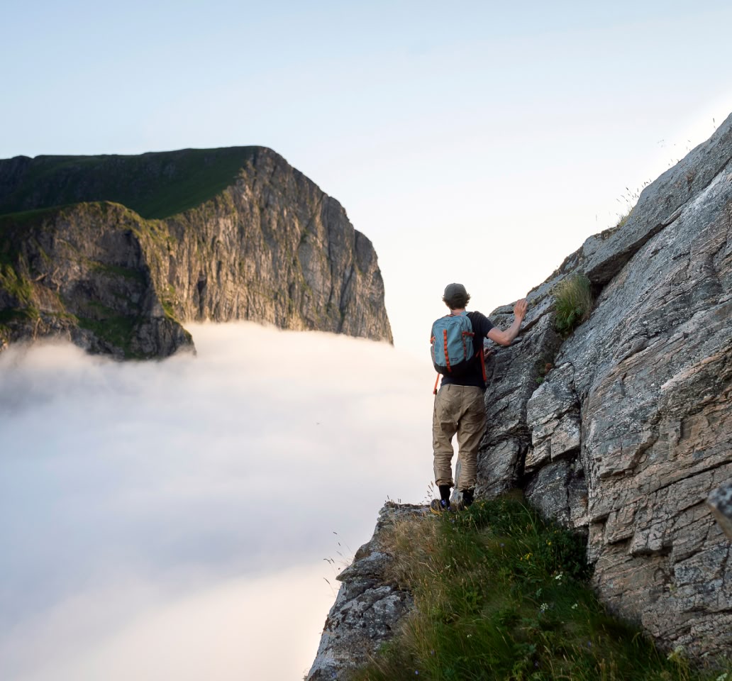 A person hiking above coastal fog.