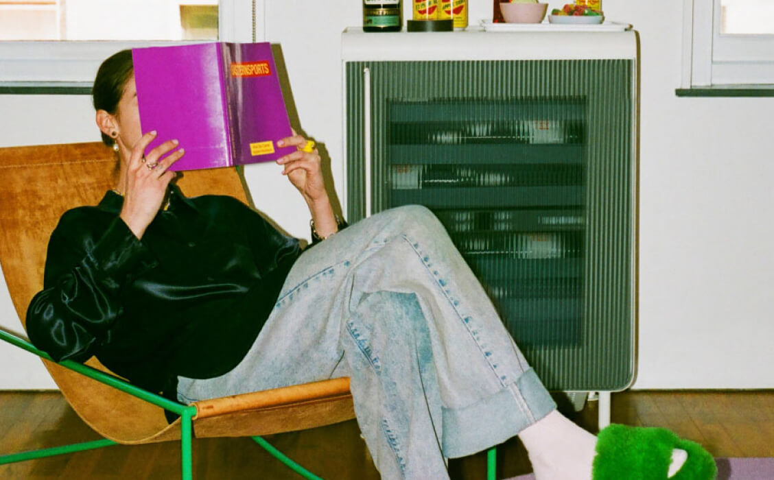 A woman reading next to her Rocco fridge