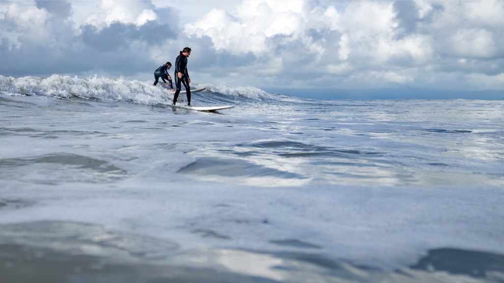 Two surfers sharing a wave.