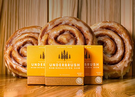 Three Honey Bun gum boxes in front of cinnamon rolls