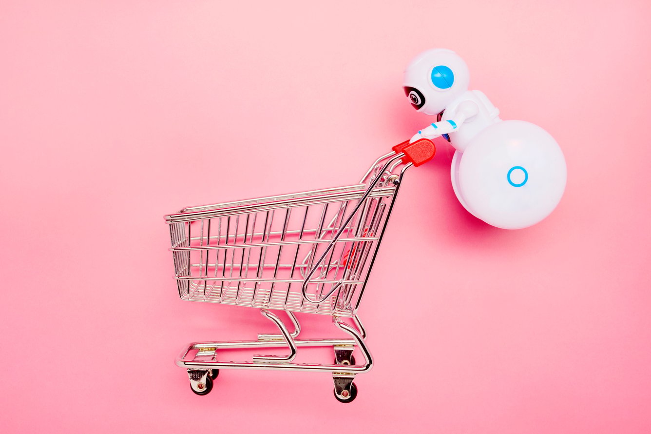 Robot pushing a shopping cart on pink background
