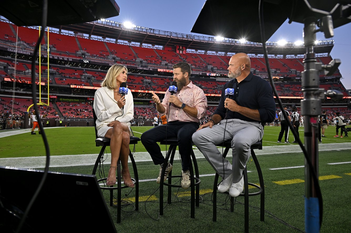 Thursday Night Football analysts shooting a segment on the field.