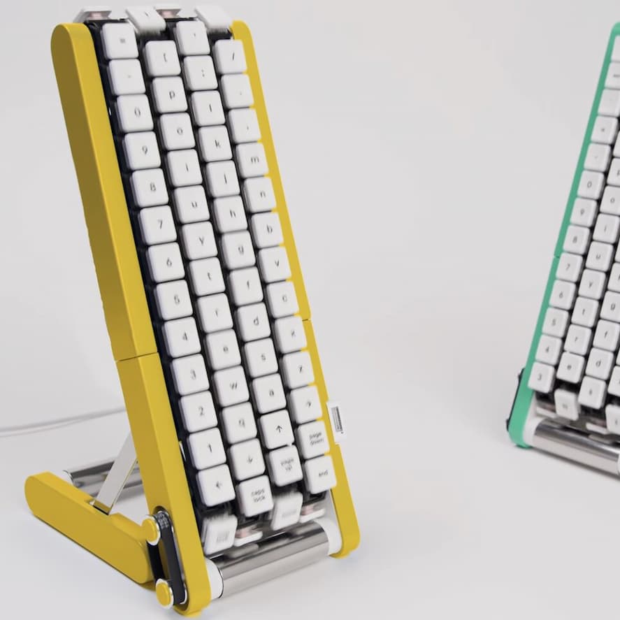 Yellow conveyor-belt keyboard standing upright, with a second green keyboard partly visible.