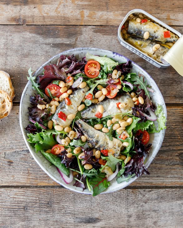 Sardines & Beans: White Beans Lemon, Garlic and Leeks. A photo of a sardine salad bowl, an open tin of sardines and a piece of bread.
