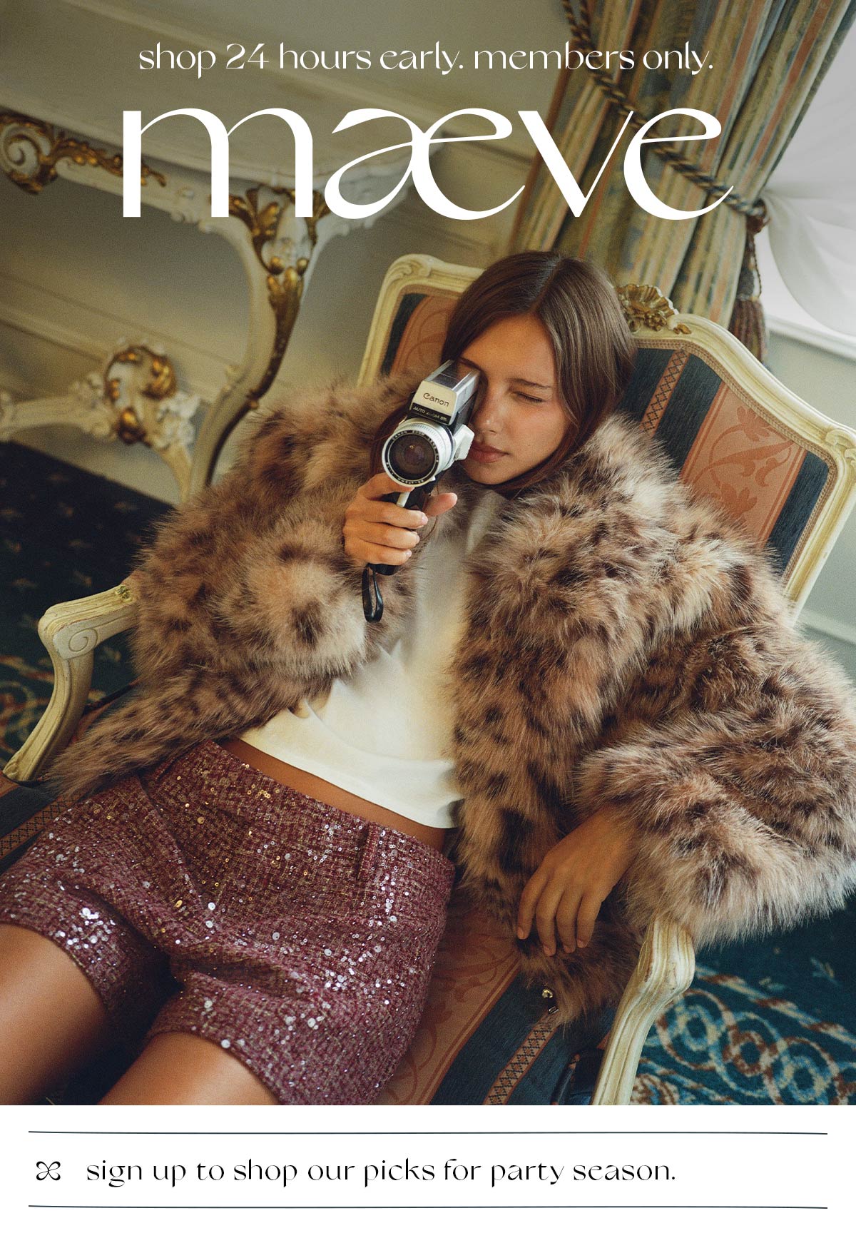  A woman sitting in an ornate armchair holding a vintage camera up to her eye. She wears a plush leopard-print faux fur coat, a white top, and sequined plum shorts. Text overlay at the top reads "shop 24 hours early. members only. maeve", and text at the bottom reads "sign up to shop our picks for party season."