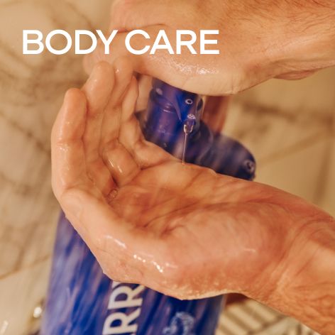 Hand pressing down on body wash pump