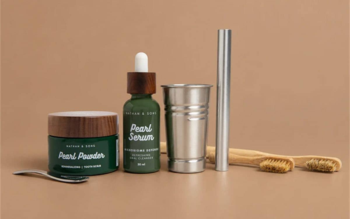 A straight-on product still life on a matte tan surface shows a dark green jar with a wood-grain lid and a matching dropper bottle, alongside a reflec...