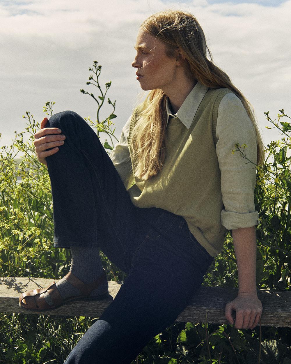 Woman sitting wearing Rinse Wash Hiut jeans.